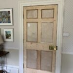 Fire-clad Craigmyle door rehung in its frame, ready for decoration