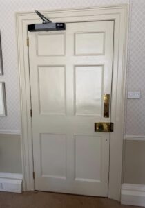 Craigmyle door rehung in situ with overhead closer and brass furniture