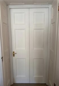 New library door-set seen from the adjoining side, sitting among matching panelled doors